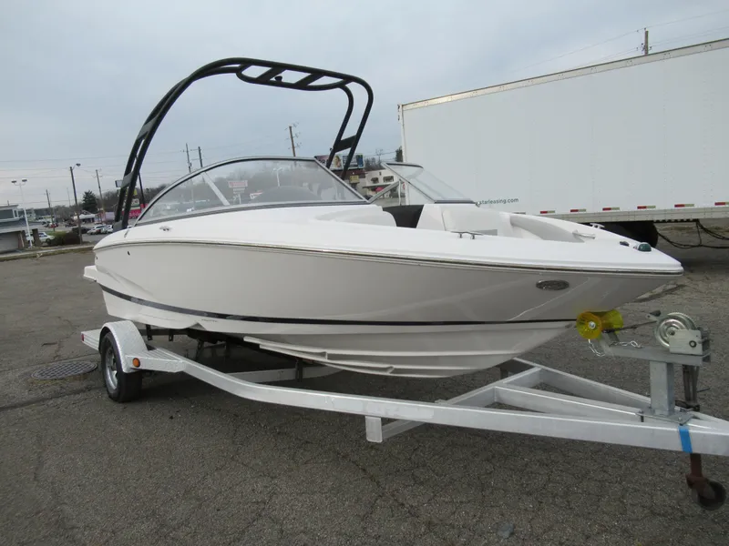 Slide: The Image of 2019 Regal 1900 ES Bowrider on trailer, white exterior, parked outdoors. - 8
