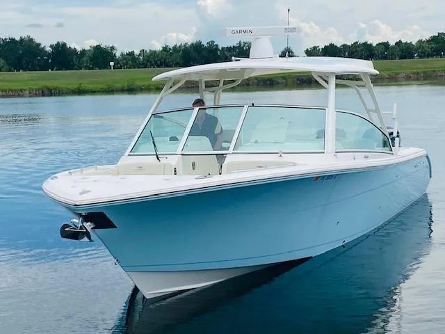 The Image of 2021 Cobia 330 Dual Console boat on a calm lake. - 0