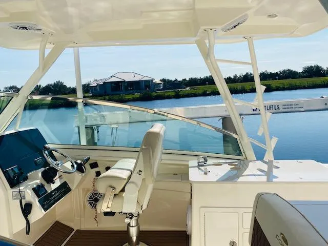 Slide: The Image of 2021 Cobia 330 Dual Console boat interior with steering wheel and seating. - 11