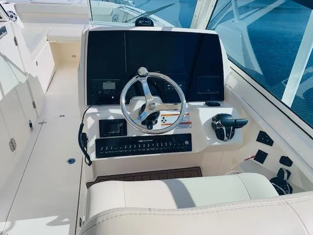 Slide: The Image of 2021 Cobia 330 Dual Console boat helm with steering wheel and control panel. - 17