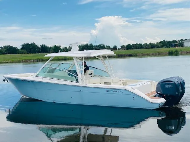 Slide: The Image of 2021 Cobia 330 Dual Console boat on calm water. - 2