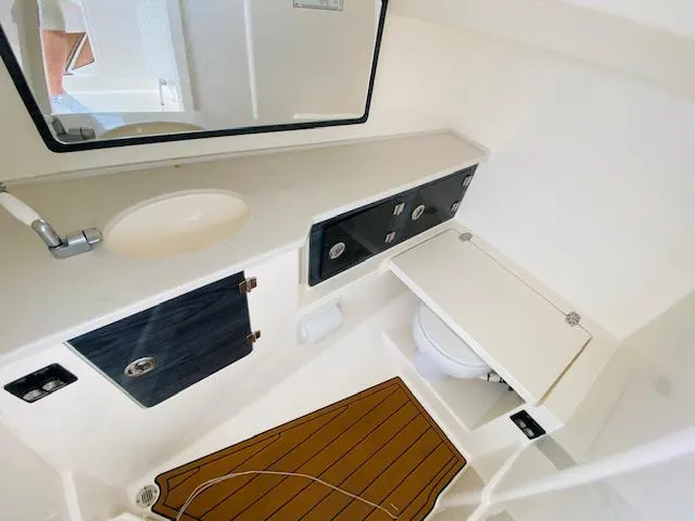 Slide: The Image of 2021 Cobia 330 Dual Console boat bathroom with sink, mirror, and toilet. - 25