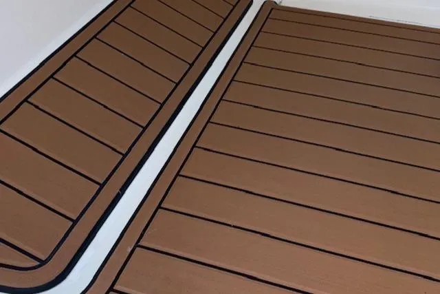 Slide: The Image of Teak flooring on a 2021 Cobia 330 Dual Console boat. - 29