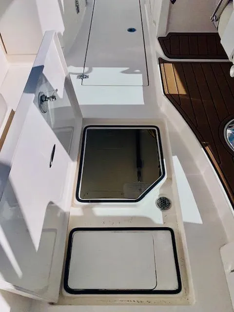 Slide: The Image of 2021 Cobia 330 Dual Console boat deck with storage compartments. - 32