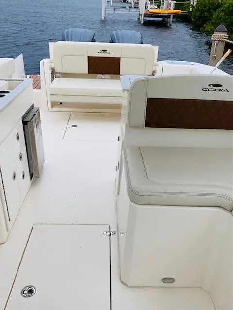 Slide: The Image of 2021 Cobia 330 Dual Console boat interior with white seating and ocean view. - 42