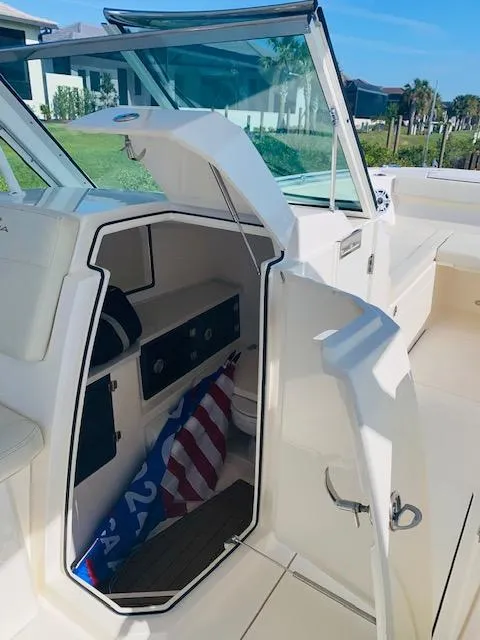 Slide: The Image of 2021 Cobia 330 Dual Console boat interior with open storage compartment. - 44