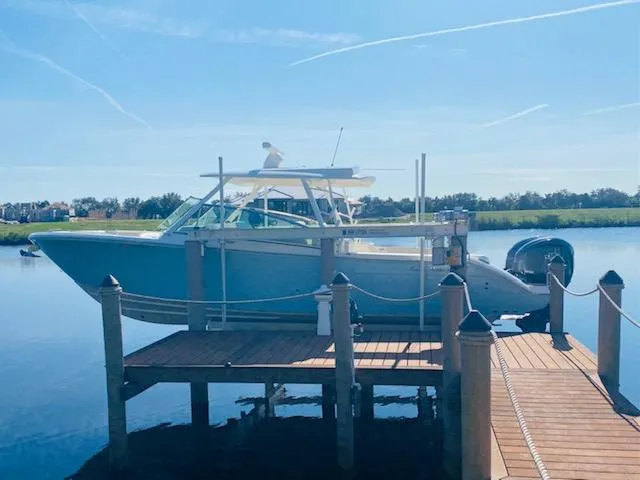 Slide: The Image of 2021 Cobia 330 Dual Console boat docked on a sunny day. - 46