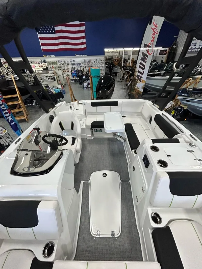 Slide: The Image of 2023 Tahoe 1950 boat interior with seating, steering console, and American flag in showroom. - 5