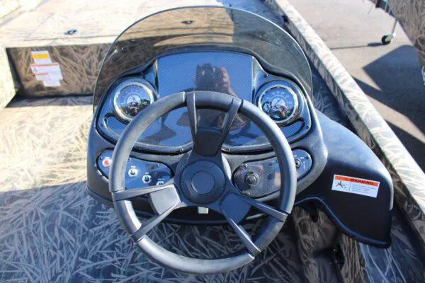 Slide: The Image of 2023 Lowe 20 Catfish boat dashboard with steering wheel and control panel. - 3