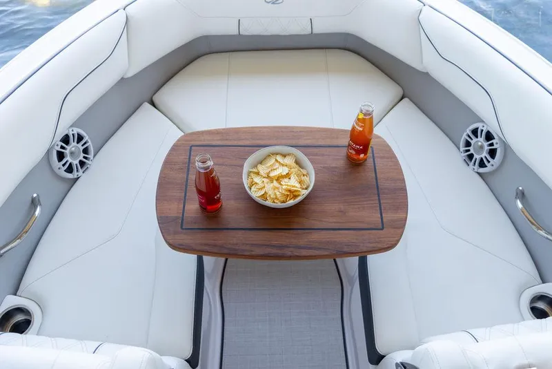 Slide: The Image of Luxurious 2025 Regal LS2 boat interior with snacks and drinks on a wooden table. - 12