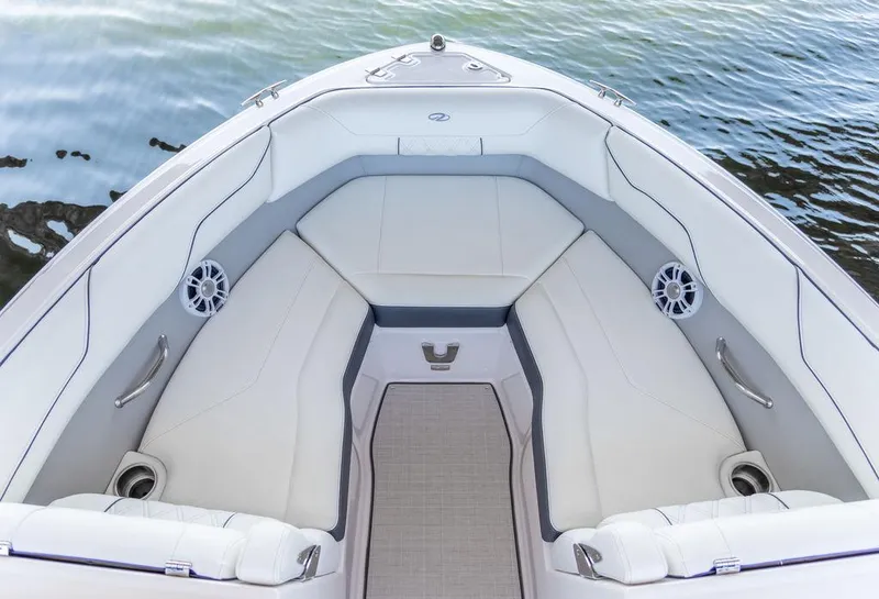 Slide: The Image of 2025 Regal LS2 boat interior with white seating and speakers, on calm water. - 14