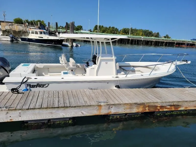 Slide: The Image of 2023 Parker 2500 SE boat docked at marina, clear blue water, sunny day. - 13