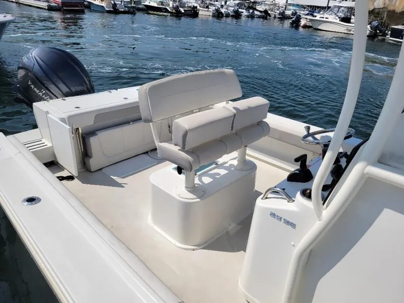 Slide: The Image of 2023 Parker 2500 SE boat interior with seating and controls, docked in a marina. - 14