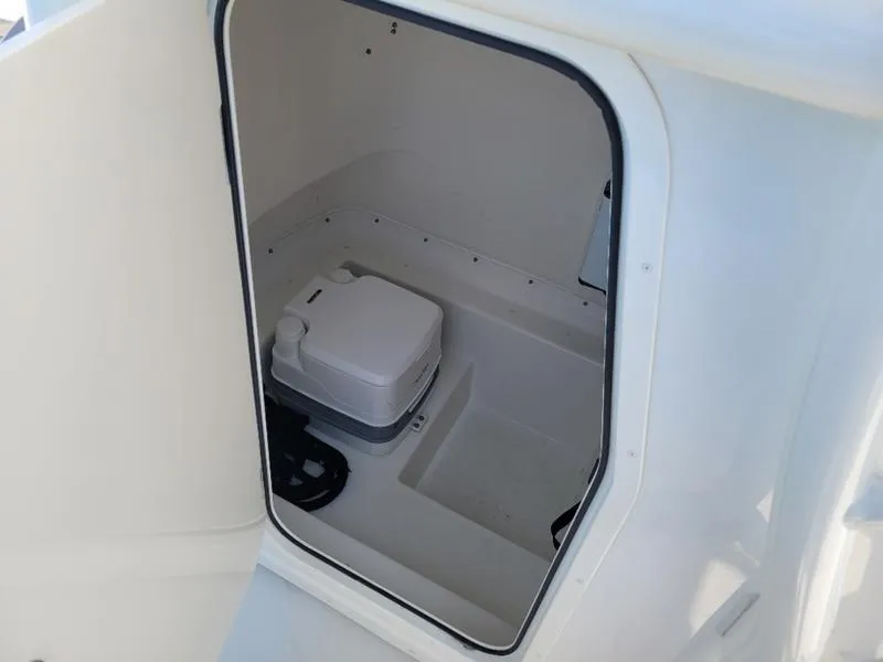 Slide: The Image of 2023 Parker 2500 SE boat interior storage compartment with portable toilet. - 2