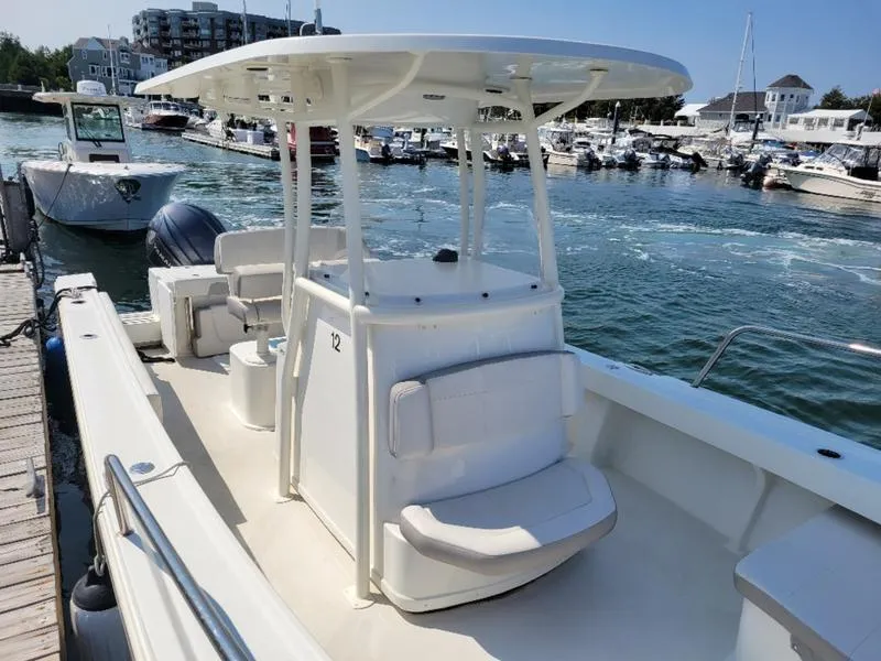 Slide: The Image of 2023 Parker 2500 SE boat docked in a marina, featuring a spacious deck and seating area. - 7