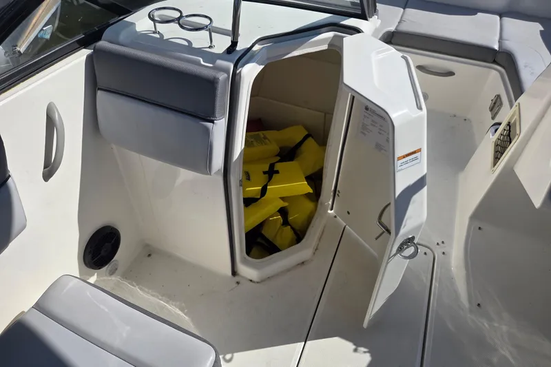 Slide: The Image of 2023 Bayliner DX 2200 boat interior with open storage compartment and life jackets. - 10