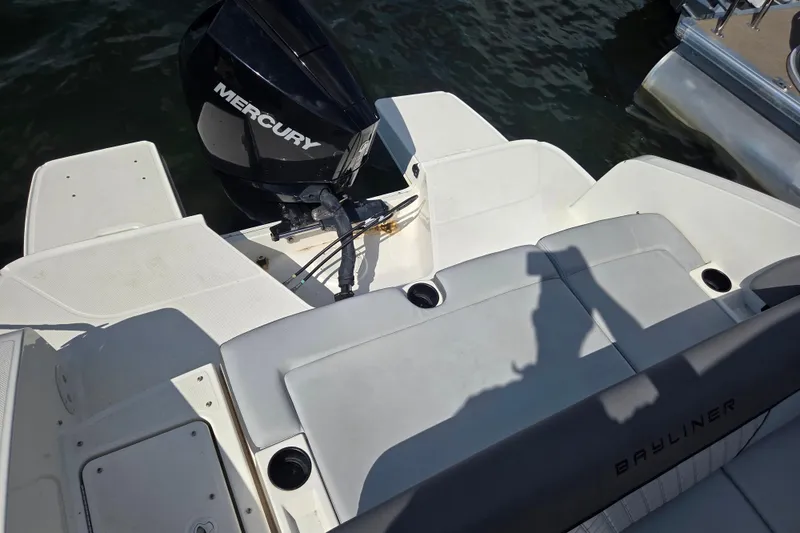 Slide: The Image of 2023 Bayliner DX 2200 boat with Mercury engine, featuring spacious seating and cup holders. - 11