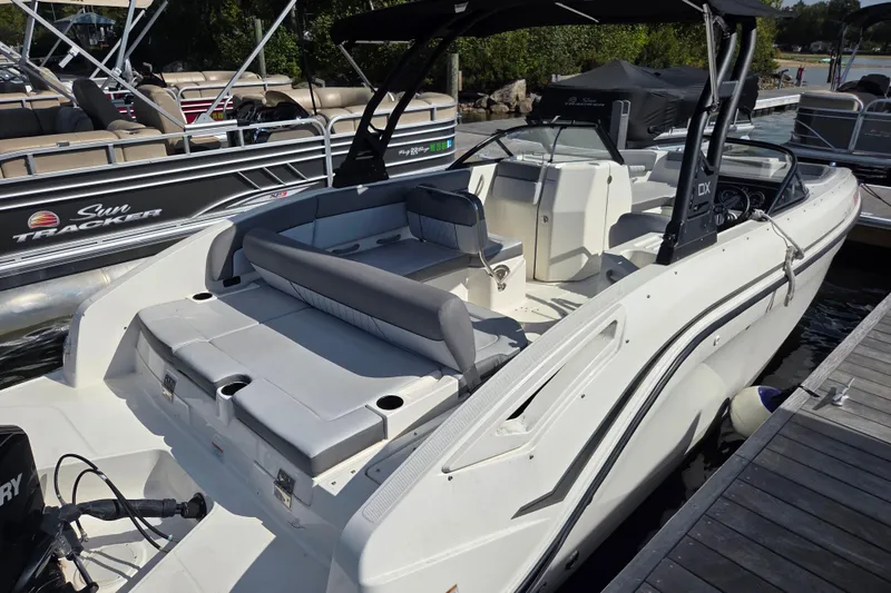 Slide: The Image of 2023 Bayliner DX 2200 boat docked, featuring spacious seating and modern design. - 3
