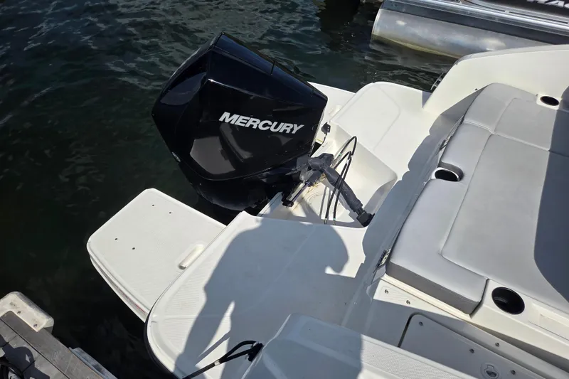 Slide: The Image of 2023 Bayliner DX 2200 boat with Mercury outboard motor, docked on water. - 4