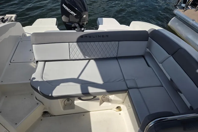Slide: The Image of 2023 Bayliner DX 2200 boat interior with gray seating and Mercury engine. - 6