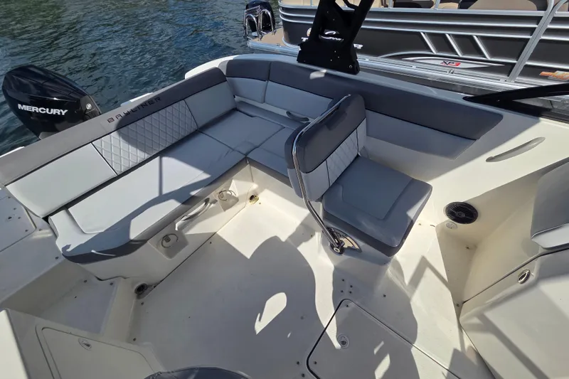 Slide: The Image of 2023 Bayliner DX 2200 boat interior with gray seating and Mercury engine. - 7