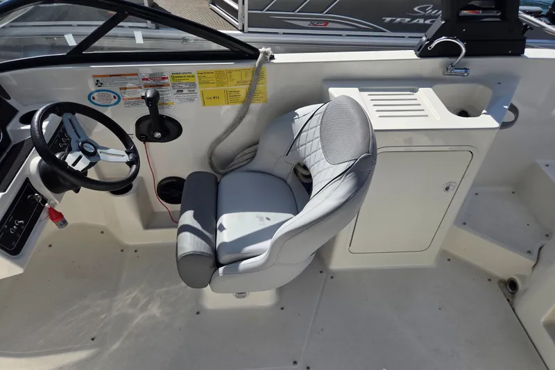 Slide: The Image of 2023 Bayliner DX 2200 boat interior with steering wheel and captain's chair. - 8