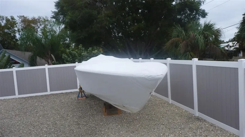 Slide: The Image of 1971 Magnum Sport boat covered and stored in a fenced yard. - 21