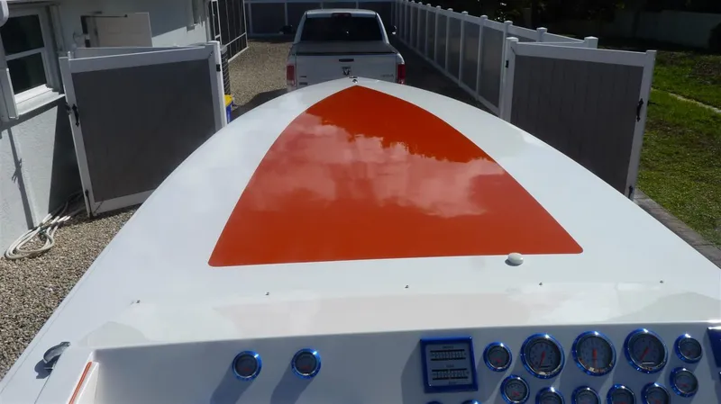 Slide: The Image of 1971 Magnum Sport boat with orange and white design, parked in a driveway. - 5