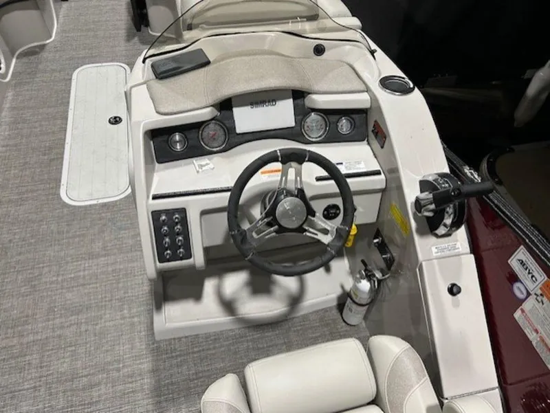 Slide: The Image of 2023 Crest Caribbean LX 230 SLS boat cockpit with steering wheel and control panel. - 11