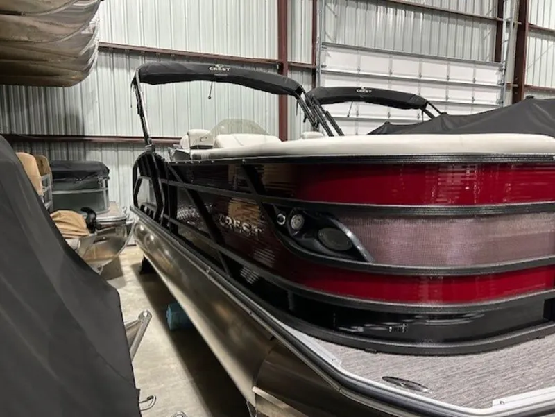 Slide: The Image of 2023 Crest Caribbean LX 230 SLS pontoon boat in storage facility. - 2