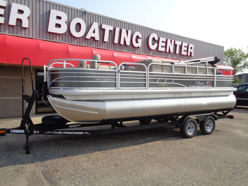 Slide: The Image of 2023 Sun Tracker Fishin' Barge 20 DLX pontoon boat on trailer outside Boating Center. - 2