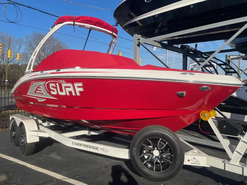 Slide: The Image of 2023 Chaparral 21 Surf boat in red on a trailer. - 2