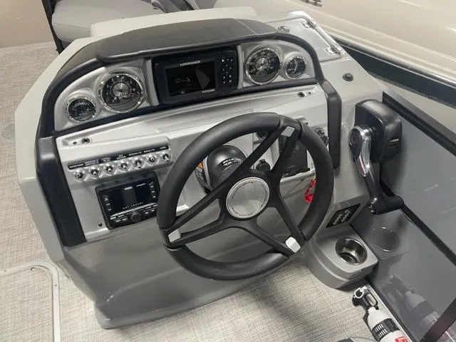 Slide: The Image of 2023 South Bay 224 UL 3.0 boat dashboard with steering wheel and control panel. - 9