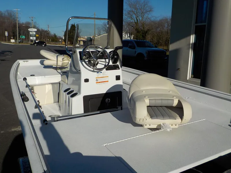 Slide: The Image of 2023 G3 Bay 17 boat with steering console and seating, parked outdoors. - 8