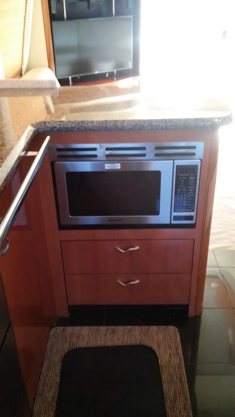 Slide: The Image of 2005 Sea Ray 550 Sedan Bridge kitchen with built-in microwave and granite countertop. - 14