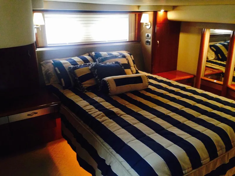 Slide: The Image of Luxurious bedroom in 2005 Sea Ray 550 Sedan Bridge yacht with striped bedding. - 15