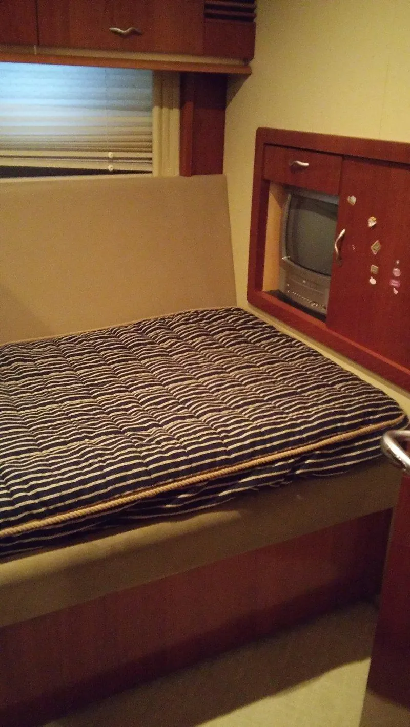 Slide: The Image of 2005 Sea Ray 550 Sedan Bridge cabin interior with bed and storage. - 18