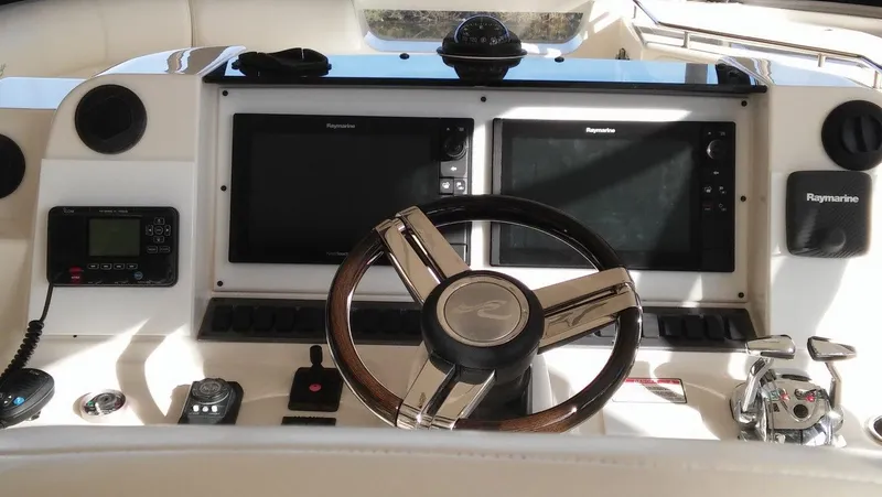 Slide: The Image of 2005 Sea Ray 550 Sedan Bridge helm with Raymarine electronics and leather-wrapped steering wheel. - 5