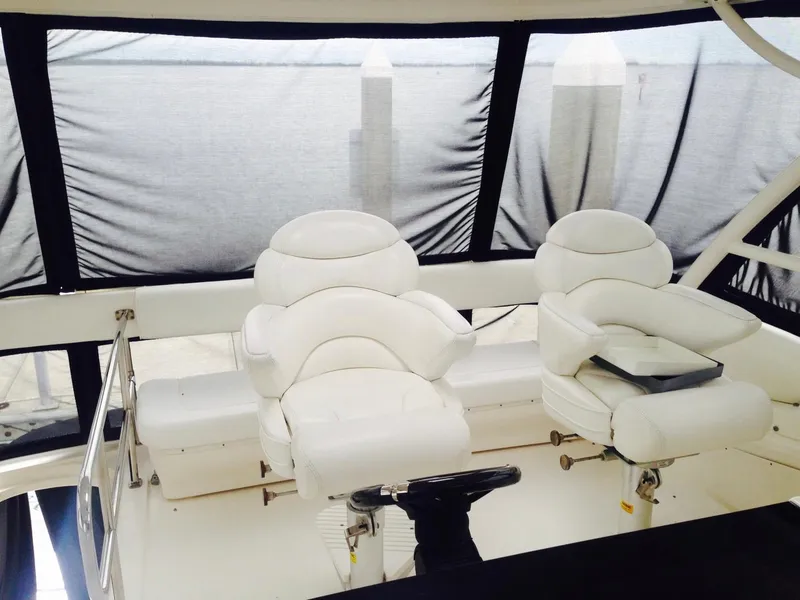 Slide: The Image of Interior helm of 2005 Sea Ray 550 Sedan Bridge with white leather seats. - 7