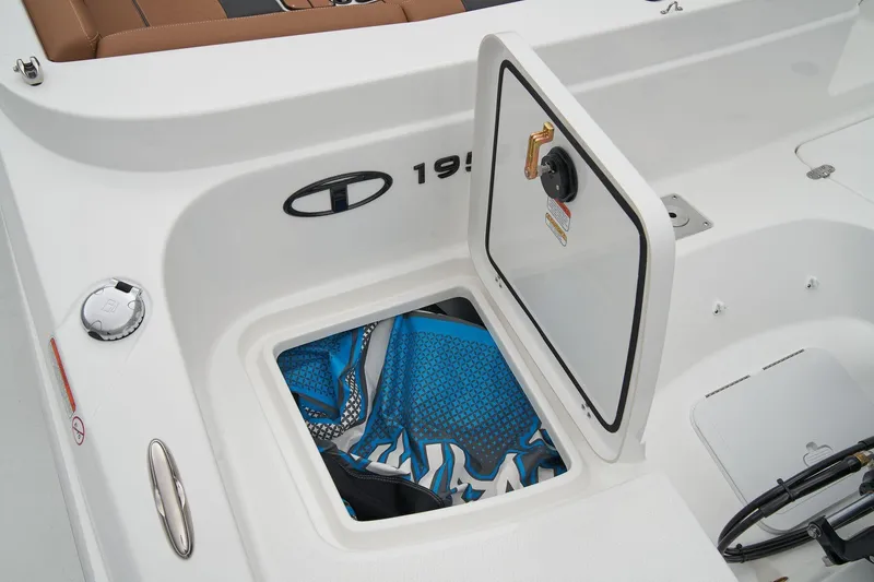Slide: The Image of 2023 Tahoe 1950 boat storage compartment with open hatch and visible gear inside. - 6