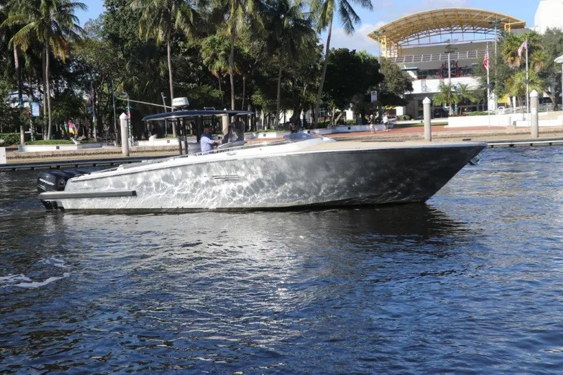 Slide: The Image of 2018 Canados Gladiator 428 boat cruising on a sunny day near a waterfront park. - 15