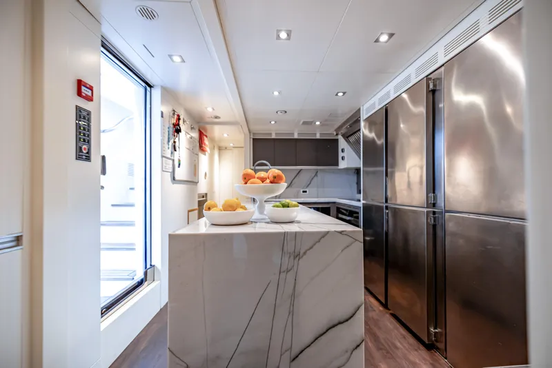 Slide: The Image of Luxurious kitchen interior on 2012 Benetti Classic Supreme 132 yacht, featuring marble island and stainless steel appliances. - 22