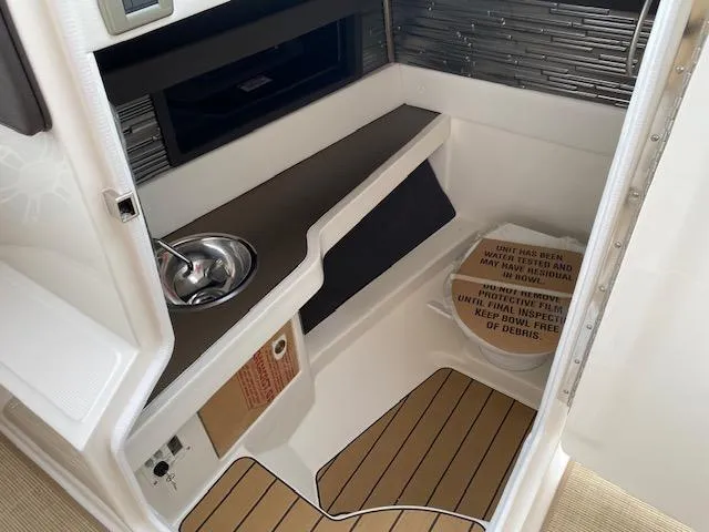Slide: The Image of 2023 Sea Ray SLX 310 OB interior cabin with sink and storage. - 20