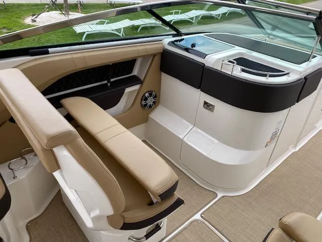 Slide: The Image of 2023 Sea Ray SLX 310 OB boat interior with beige seating and modern dashboard. - 23