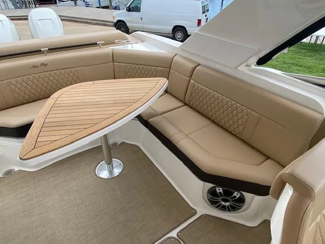 Slide: The Image of Luxurious seating area on the 2023 Sea Ray SLX 310 OB boat with a wooden table. - 30