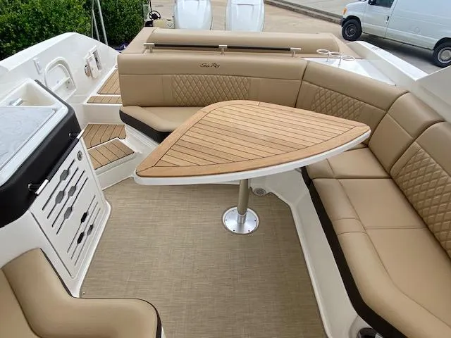 Slide: The Image of Luxurious seating area on the 2023 Sea Ray SLX 310 OB boat with a stylish wooden table. - 31