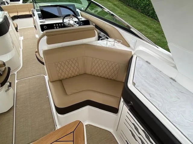 Slide: The Image of 2023 Sea Ray SLX 310 OB boat interior with tan seating and modern dashboard. - 32