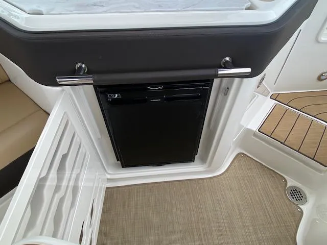 Slide: The Image of 2023 Sea Ray SLX 310 OB interior with built-in mini fridge. - 34