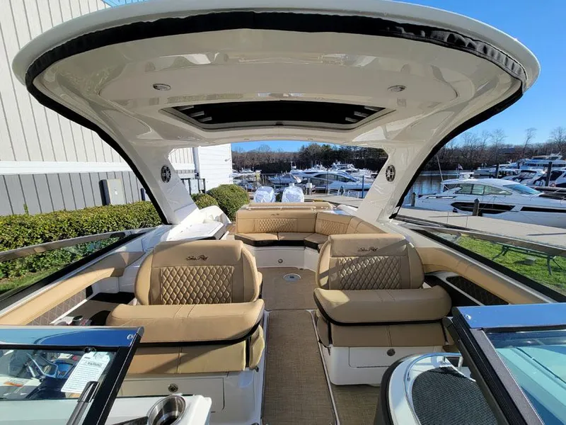 Slide: The Image of 2023 Sea Ray SLX 310 OB luxury boat interior with tan seating and modern design. - 9