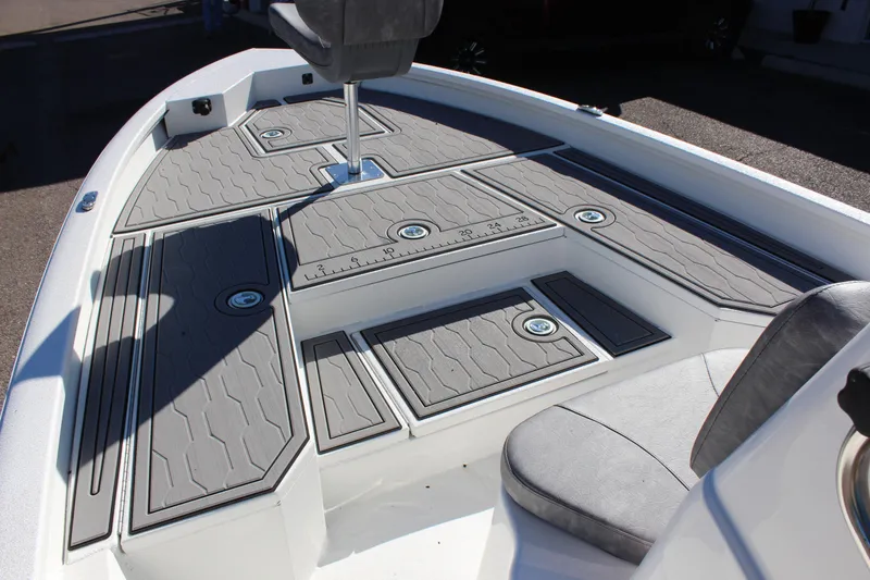 Slide: The Image of 2023 Avid 21 Mag boat deck with gray non-slip flooring and storage compartments. - 11